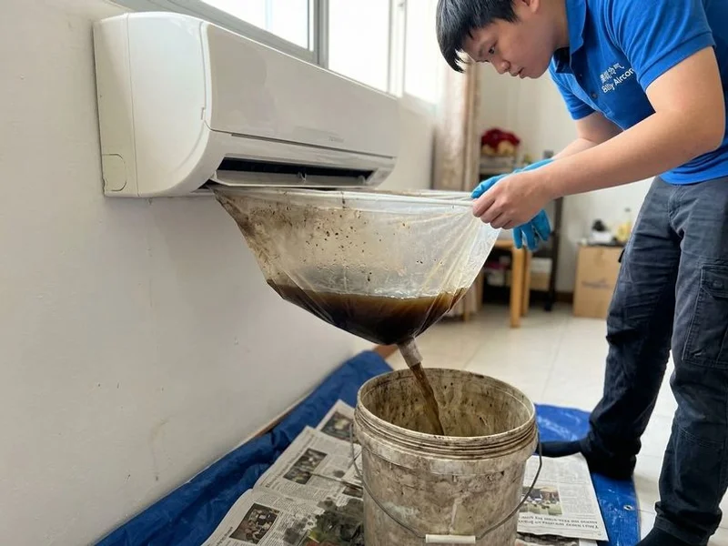 Dark contaminated water draining from aircon unit during chemical wash process