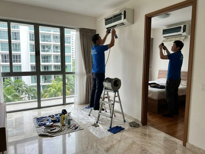 Technician servicing multiple aircon units in a Singapore condominium
